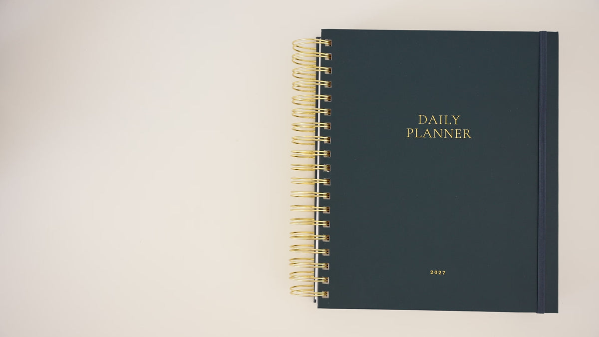 Load video: Person opening the 2027 Navy daily spiral planner showing the interior pages