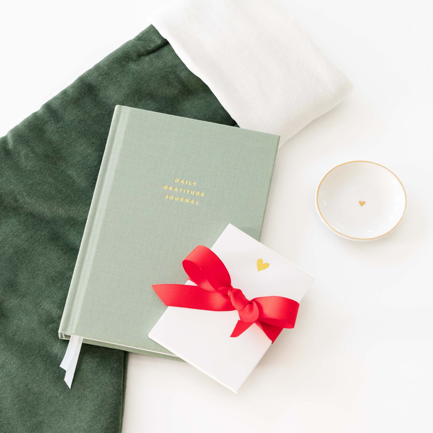 green Christmas stocking with green journal, mini notepad, and trinket tray