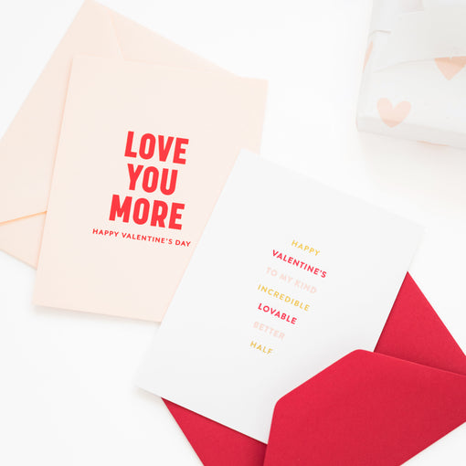 Valentine's Day card with 'Love You More' text and a red envelope on a white background.