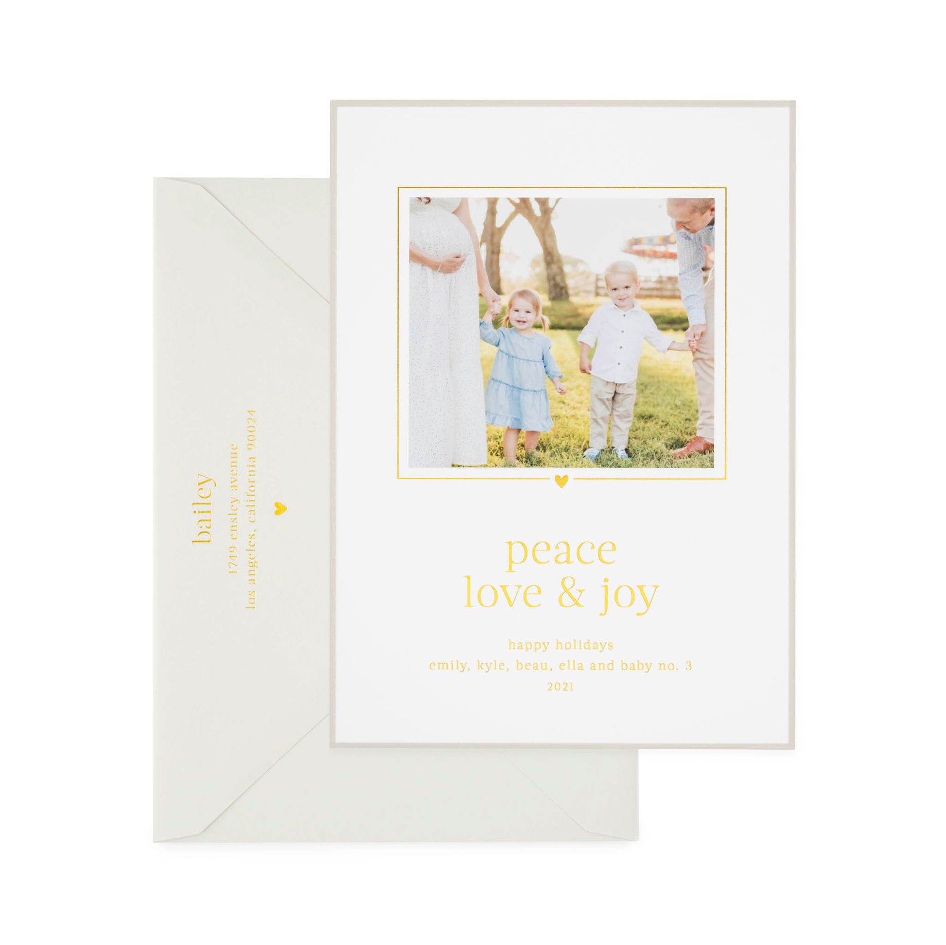 Custom holiday photo card printed with "peace love and joy" in gold foil with a photo of two kids and parents with a grey card border paired with a grey envelope