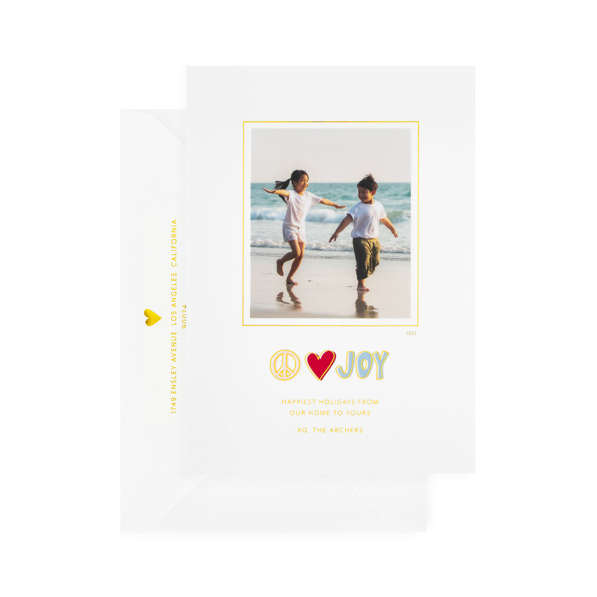 white card with photo and multicolor text, white envelope with gold text