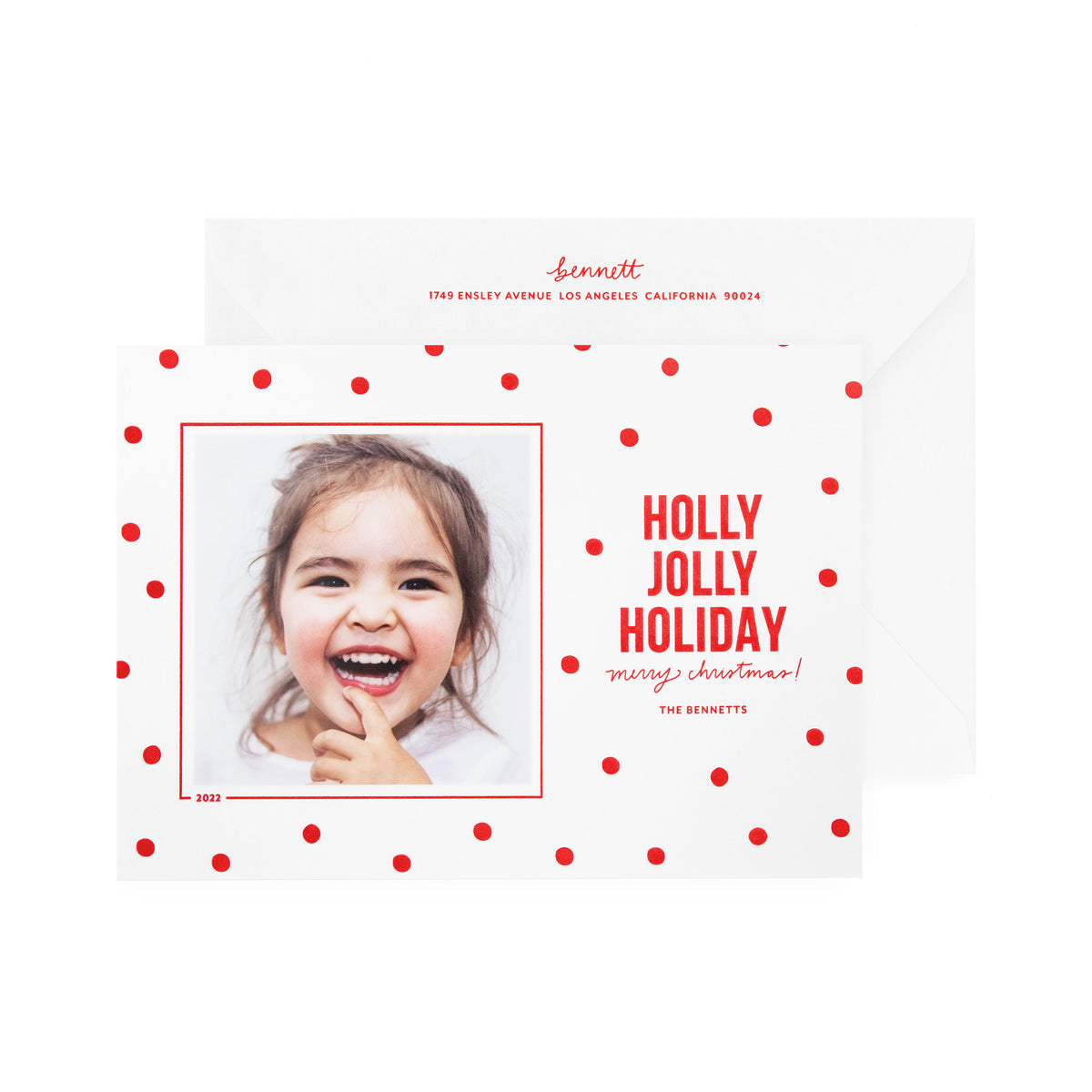 white card with photo, red dots and red text, white envelope with red text