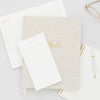 Stacked note pads and agenda in white and gold