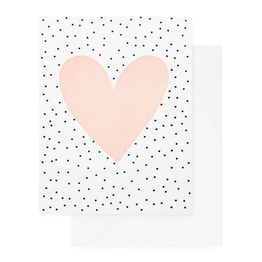 white card with black scattered dots and pale pink heart, white envelope