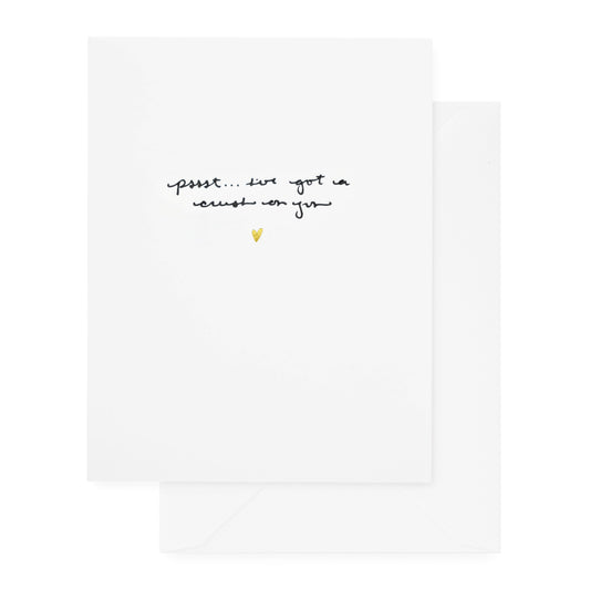 white card with black pssst... i've got a crush on you script with gold foil heart, white envelope