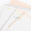 Stack of grey and pale pink planning pads.
