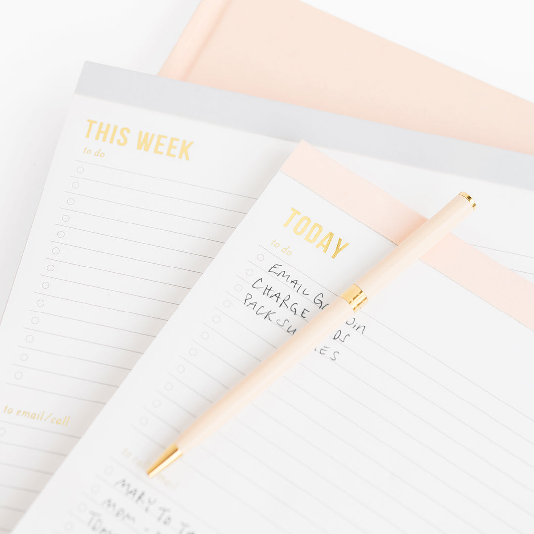 Stack of grey and pale pink planning pads.