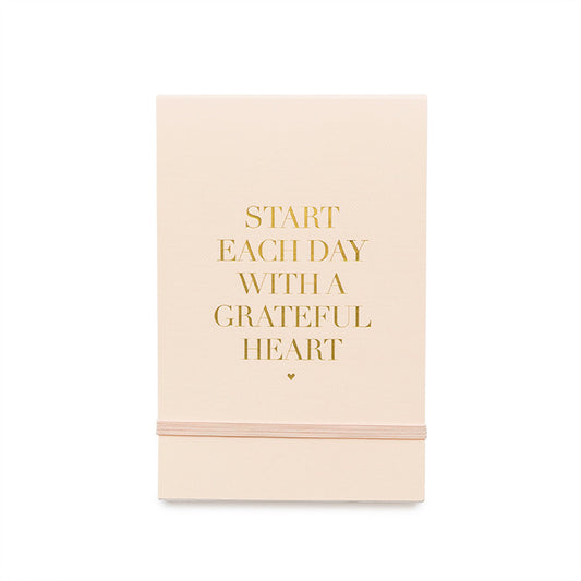 pale pink mini note pad with gold foil "Start Each Day With a Grateful Heart" and pink elastic band