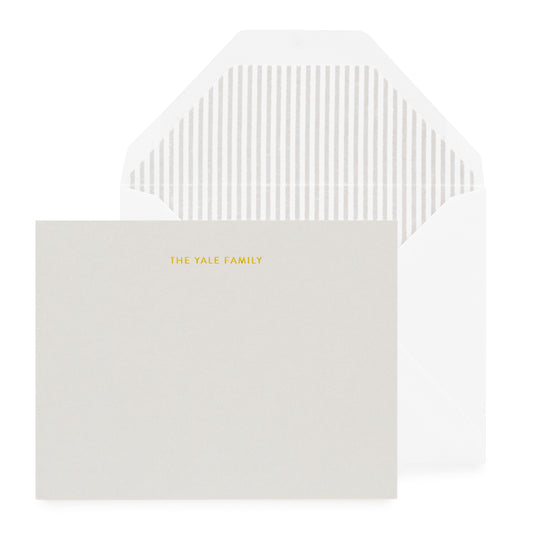 grey card with gold foil text, whit envelope with grey striped liner