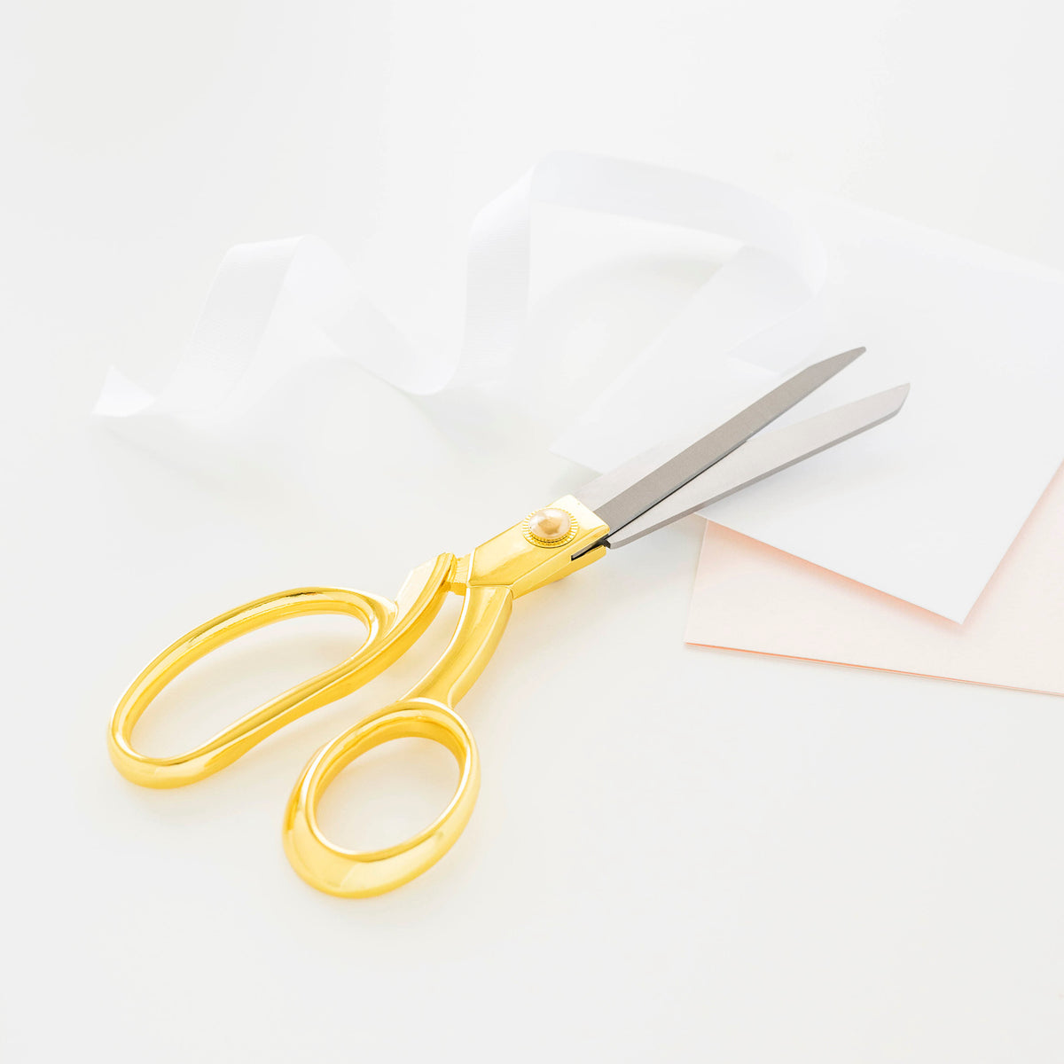gold handled scissors with loose paper and ribbon