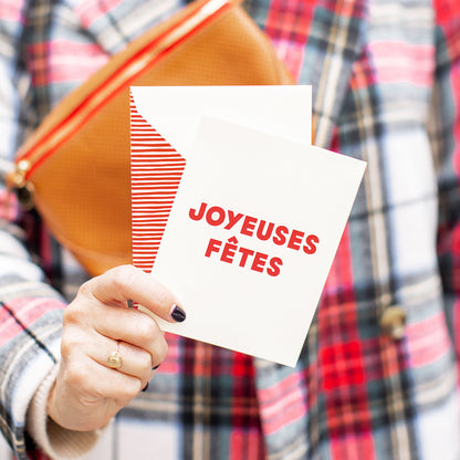 person holding joyeuses fetes card 