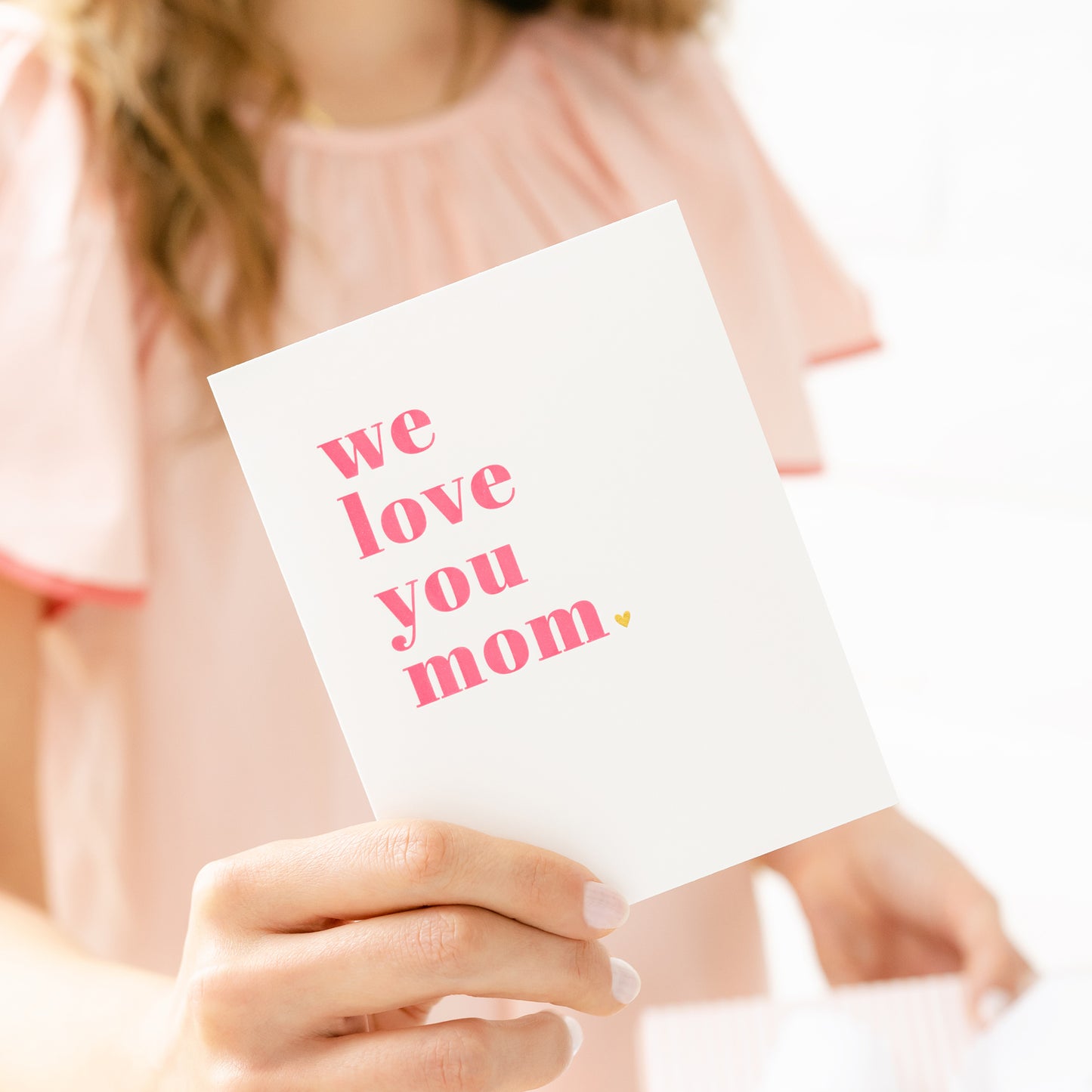 person holding we love you mom card