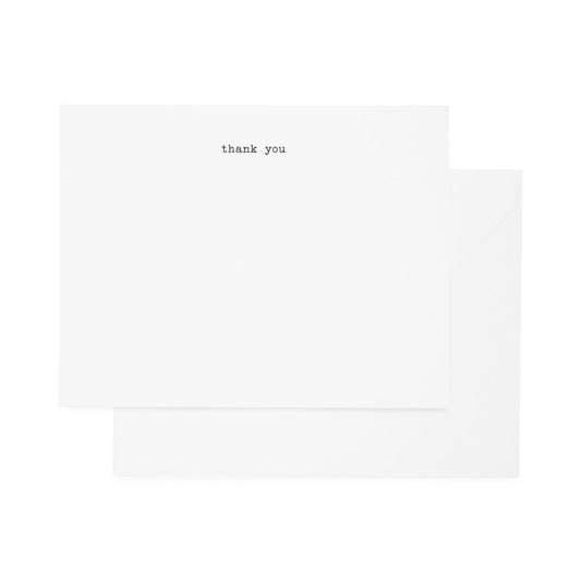 A simple thank you note card set with 'thank you' printed in a typewriter font, accompanied by envelopes.