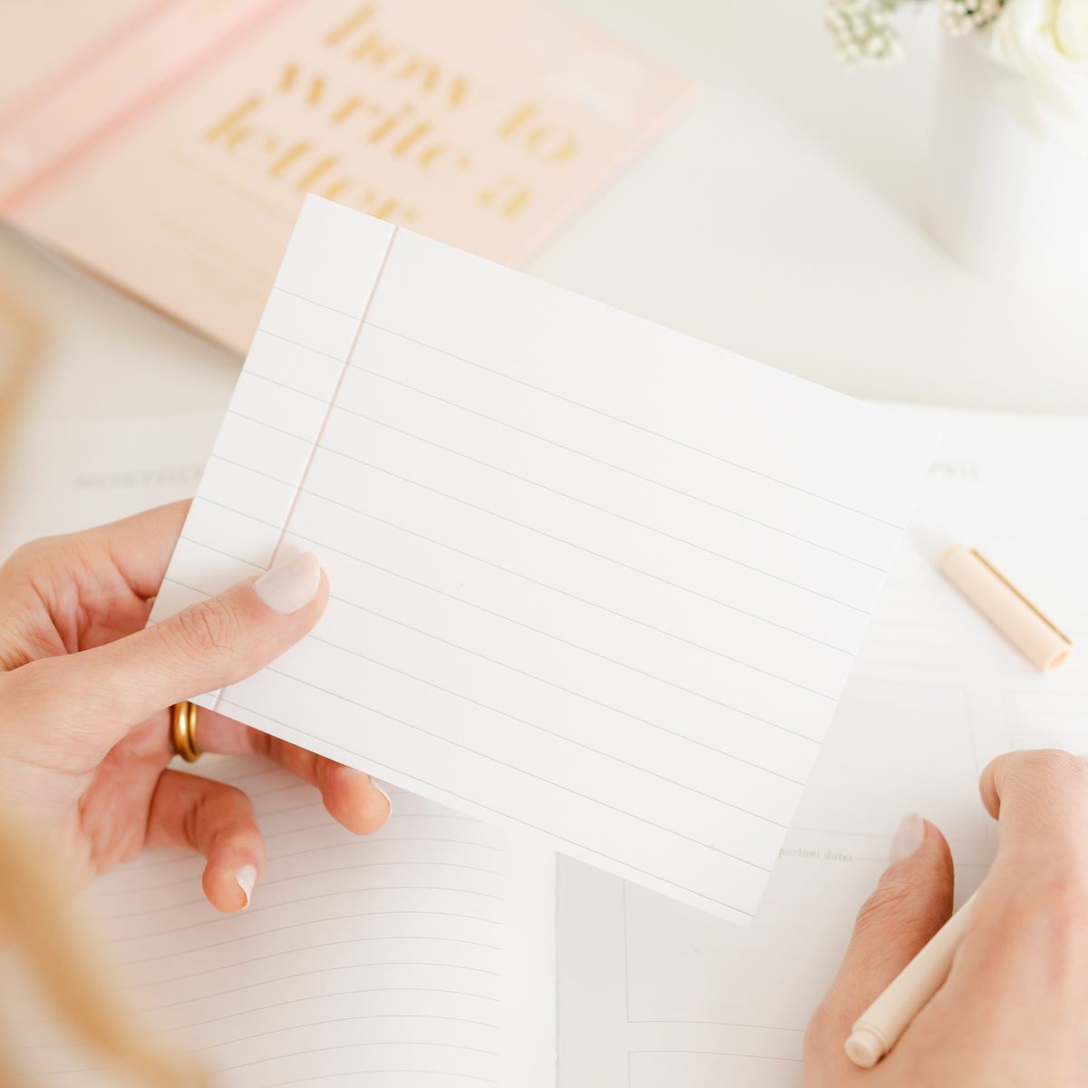 person holding notebook paper card with pen