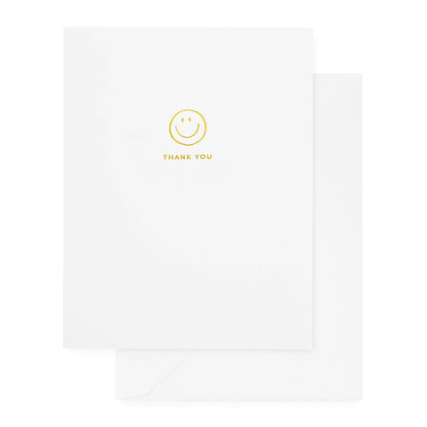 white card with gold foil smiley and thank you text, white envelope
