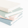 Stack of four tailored journals in different colors