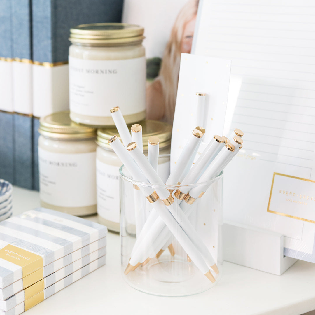 White and brass twist pens in cups