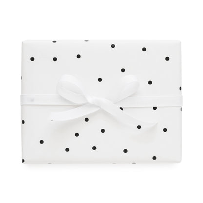 white gift wrap with black scattered polka dots and white bow